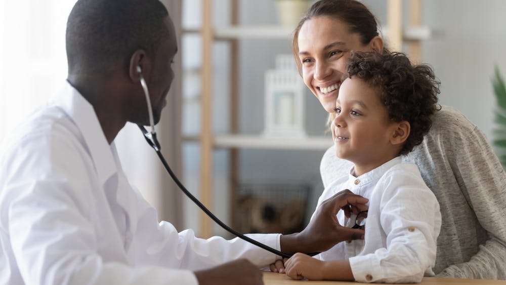 A medical provider checking a child with a stethoscope 